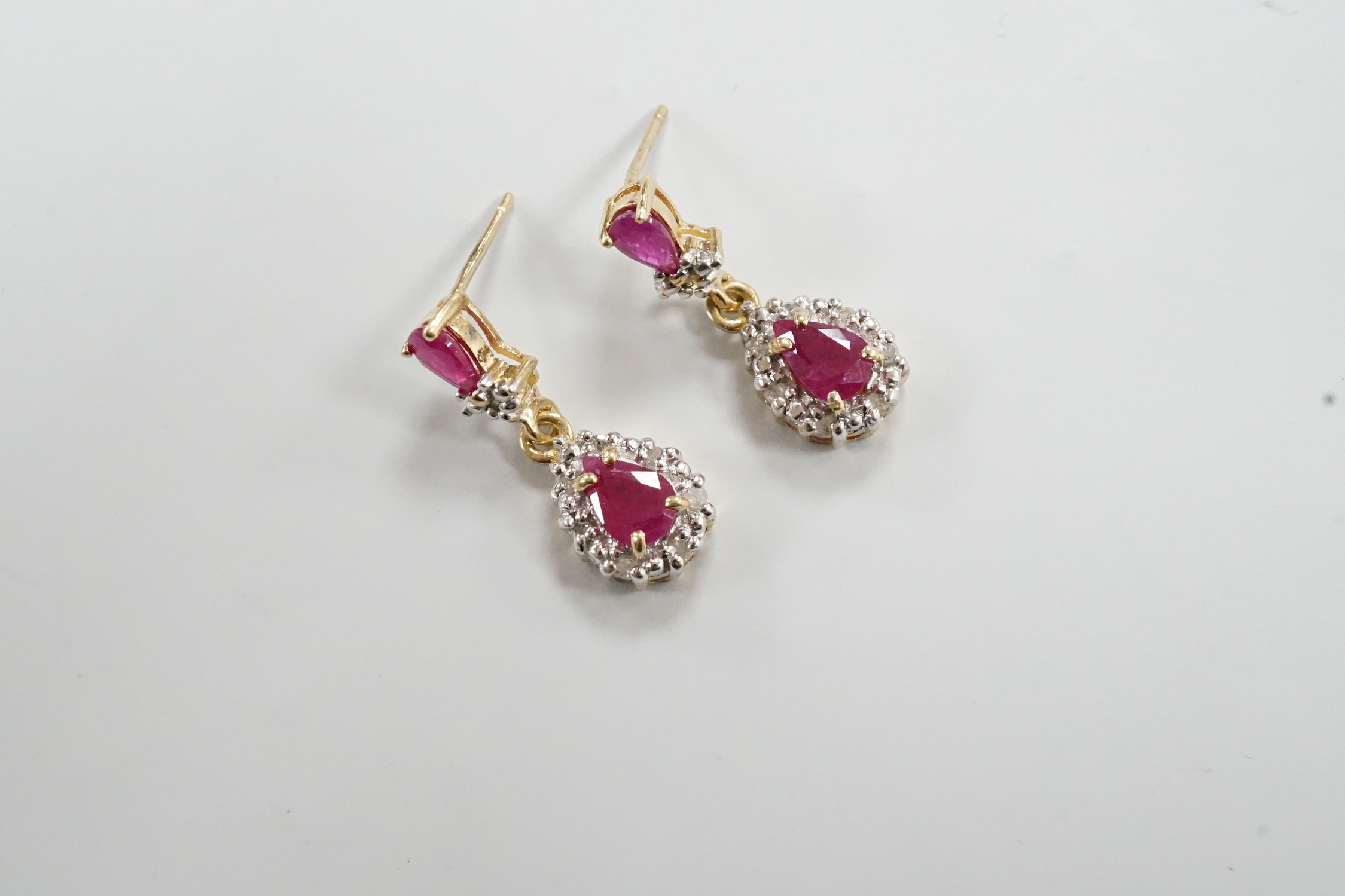A modern pair of 18k yellow metal, ruby and diamond set pear shaped cluster drop earrings, 20mm, gross weight 3 grams.